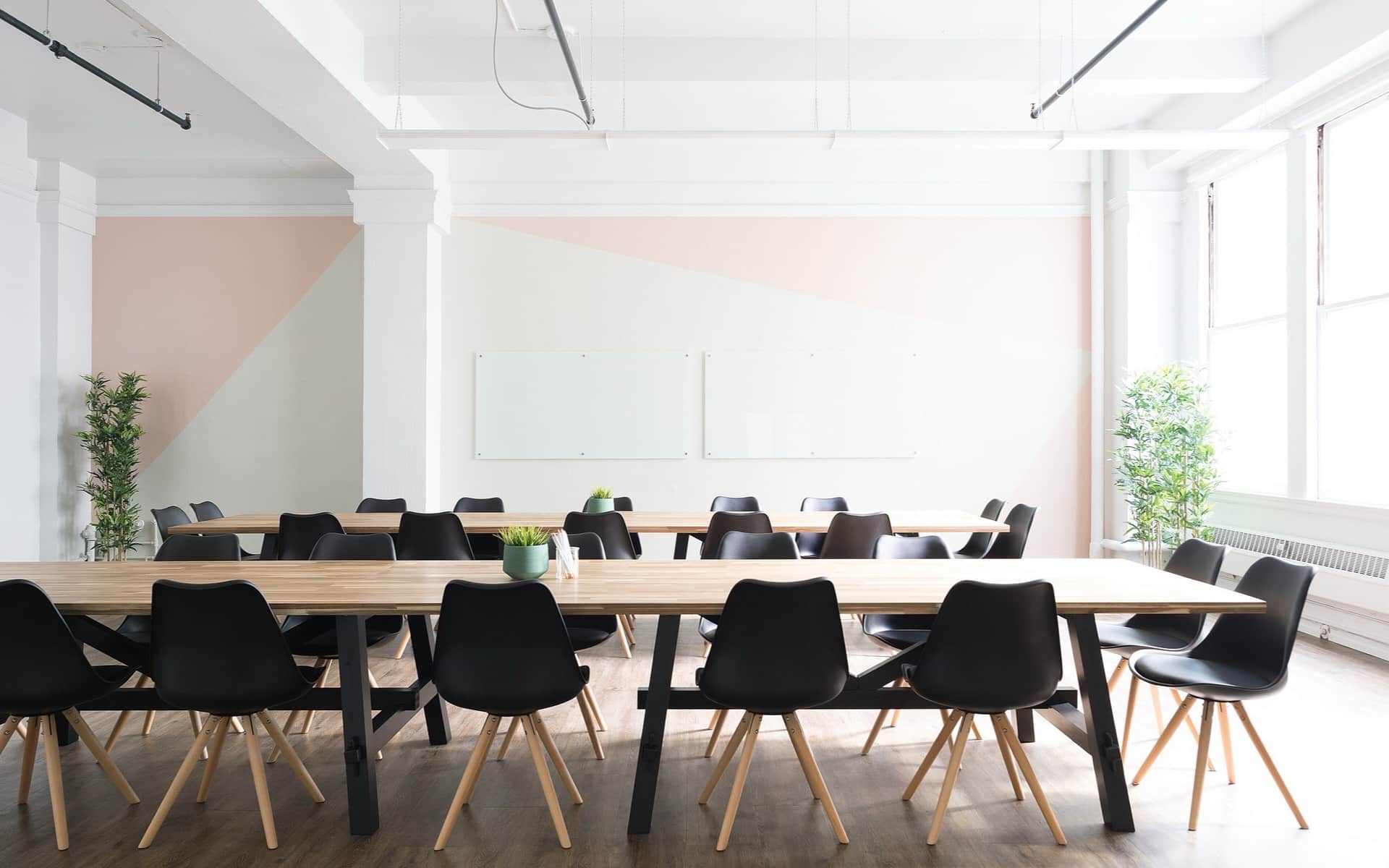 A long meeting table set with chairs in a bright, empty boardroom.