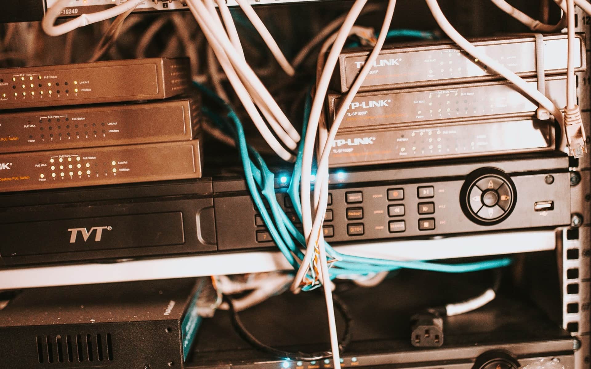 Switches und Router übereinander in einem Rack, Patchkabel laufen zwischen ihren Ports.