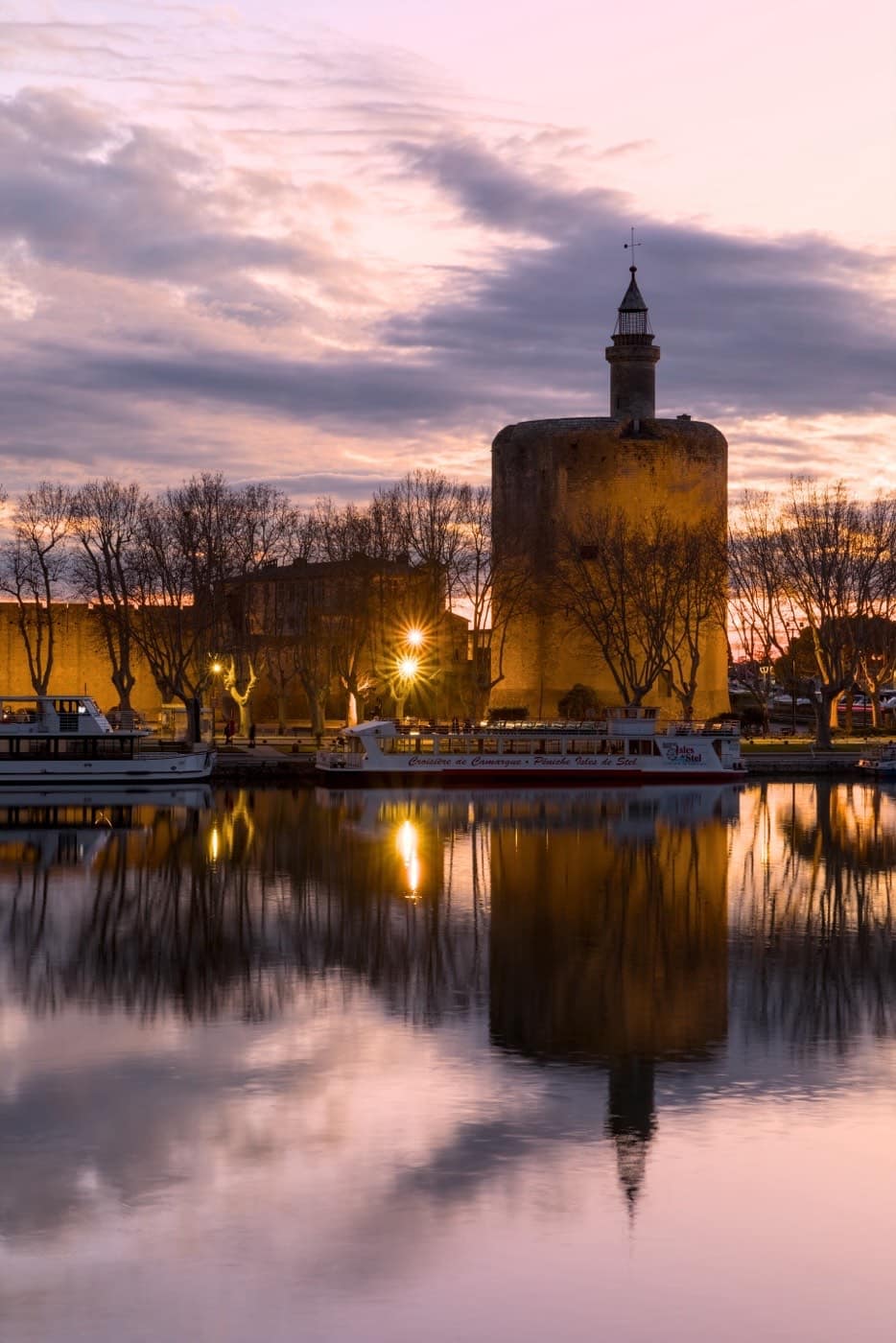 A single fortified tower of Aigues-Mortes seen from below at dusk.