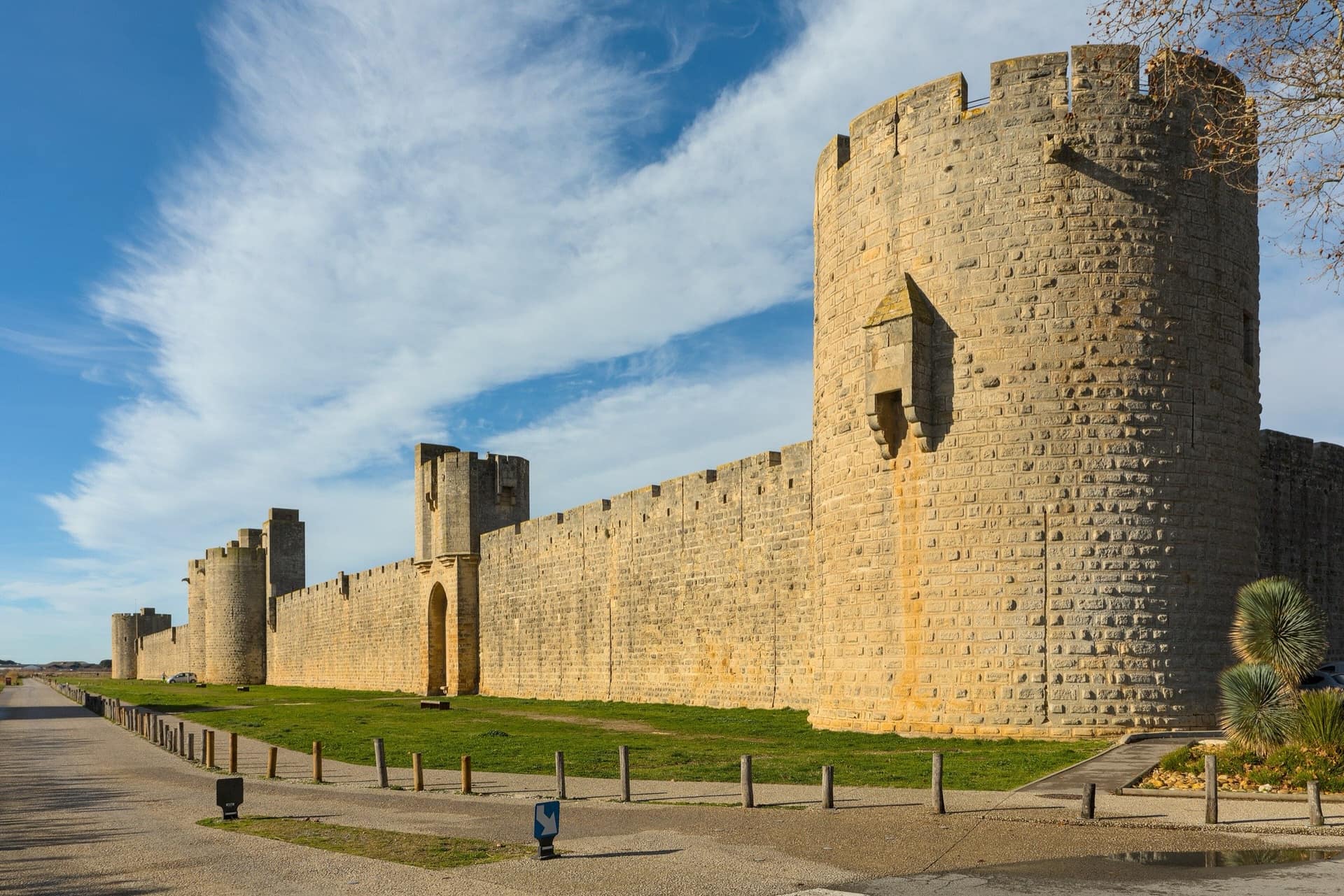 A long stretch of the Aigues-Mortes curtain wall, its courses of cut stone running the full width of the frame.