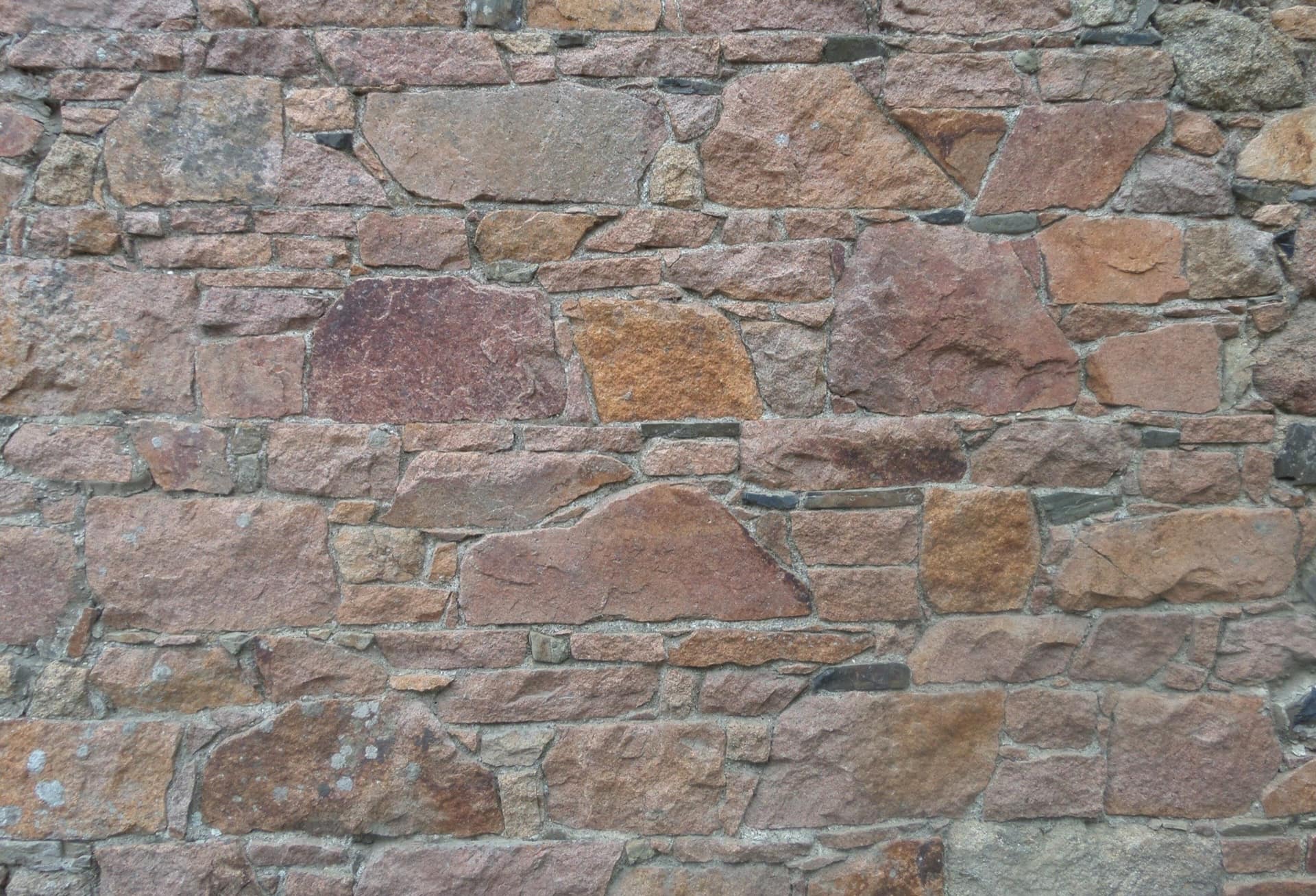 Close view of a dry-stone wall, each course laid slightly differently from the one beneath it.