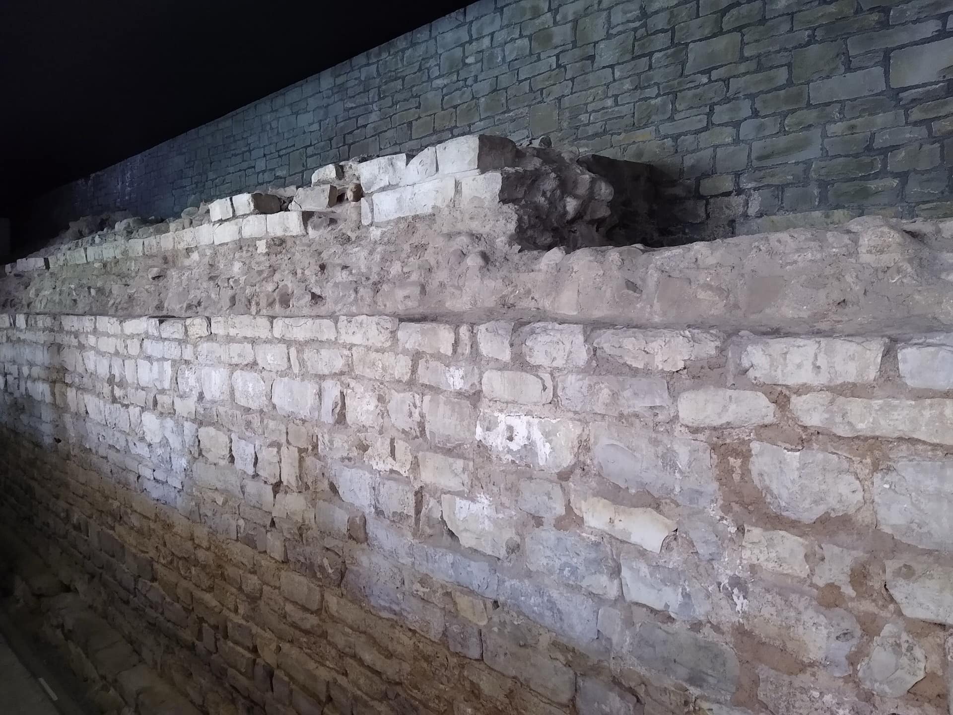 A surviving section of Roman wall, its original masonry set clearly apart from the later work built above it.