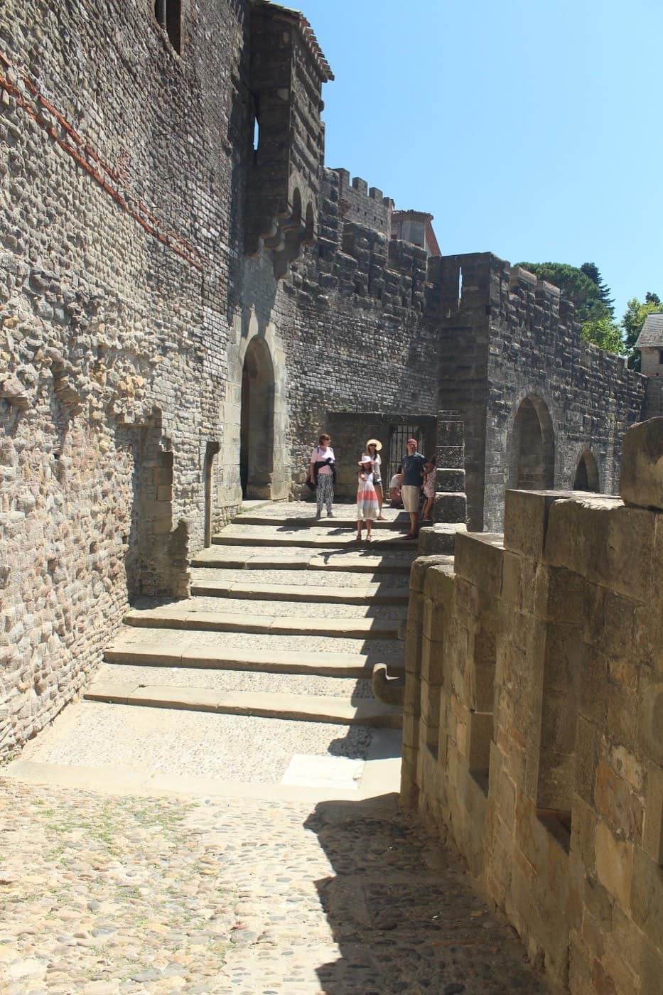 A stone stair climbing the inside of the fortified walls of Carcassonne, one step at a time.